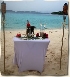 Tiki torches accenting rum punch set up at Lindquist Beach wedding