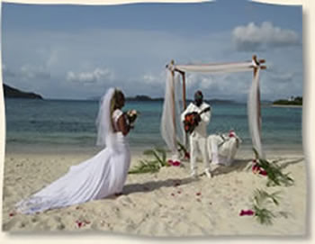 Bride walking aisle as groom serenades her at her island wedding.